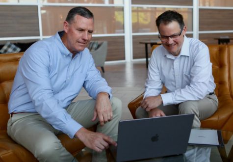 A photo of two HWAW Staff members having a discussion over a laptop A photo of two HWAW Staff members having a discussion over a laptop