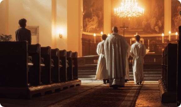 A procession of a Priest, the cross bearer and acolyte with candle at the start of a Catholic Mass. A procession of a Priest, the cross bearer and acolyte with candle at the start of a Catholic Mass.
