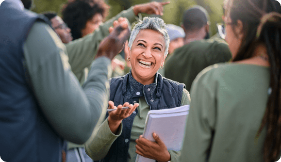 A joyful employee interacting with her fellow workers in a warm and upbeat environment. A joyful employee interacting with her fellow workers in a warm and upbeat environment.